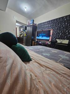 a bedroom with a large bed with a flat screen tv at Gamingcation in Manila