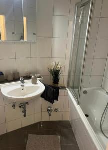 ein weißes Badezimmer mit Waschbecken und Dusche in der Unterkunft Schleibude in Schleswig + 5 Fotos
