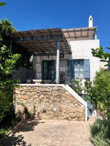 una casa con una pared de piedra delante de ella en Summer Villa Zefiros, close to Kaiki beach, en Spetses