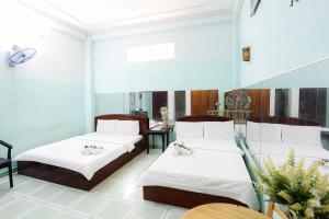 una camera d'albergo con due letti e un tavolo di Hồng Lực Hotel HCM ad Ho Chi Minh