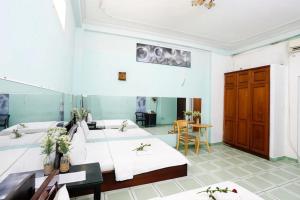 una camera con quattro letti e un tavolo con fiori di Hồng Lực Hotel HCM ad Ho Chi Minh
