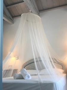 un letto con zanzariera sopra. di Summer Villa Zefiros, close to Kaiki beach a Spetses