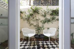 two chairs and a table in front of a wall at Boutique Studio Apartment in Heritage Home in Sydney