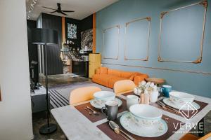 a living room with an orange couch and a table at Ipoh Fumei Boutique Residence House By Verve in Ipoh