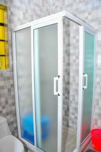 a shower with a glass door in a bathroom at Gatville Serene Gardens in Kiserian