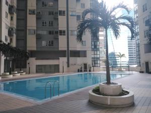 a palm tree next to a swimming pool in a building at 2 Bedrooms Units Forbes Area 5th Avenue BGC Center in Manila
