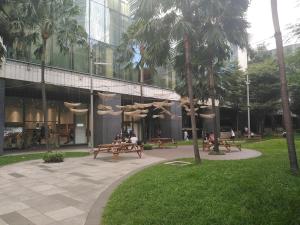 a building with benches and palm trees in a park at 2 Bedrooms Units Forbes Area 5th Avenue BGC Center in Manila