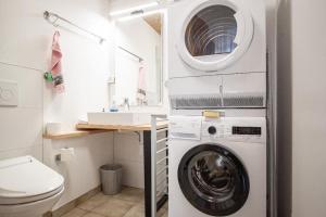 a bathroom with a washing machine and a sink at Wonderful Lake View Retreat in Gambarogno