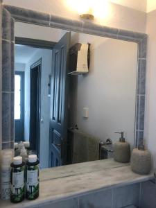 bagno con grande specchio e lavandino di Summer Villa Zefiros, close to Kaiki beach a Spetses