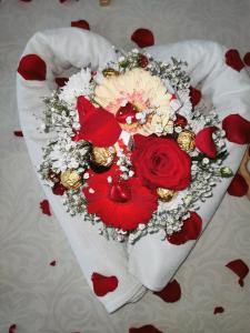 a heart shaped bouquet of flowers on a bed at Teslić Apartman NiA in Teslić