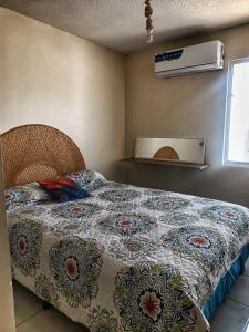 ein Schlafzimmer mit einem Bett mit einer Decke darauf in der Unterkunft Airport Hostel in Ciudad Juárez
