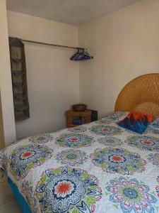 a bed with a quilt on it in a bedroom at Airport Hostel in Ciudad Juárez