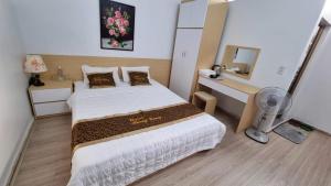 a bedroom with two beds and a mirror at Hương Giang Hotel & Coffee in Thái Bình
