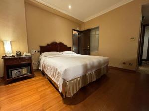 a bedroom with a large bed and a fireplace at Royal Seasons Hotel Taipei ‧ Nanjing W. in Taipei