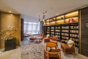 une bibliothèque avec des chaises, des tables et des étagères dans l'établissement Atour S Hotel Guangzhou Beijing Road Tianzi Wharf, à Canton