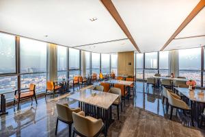 a restaurant with tables and chairs and large windows at Atour Hotel Zhongshan Ancient Town Huayi Plaza in Zhongshan