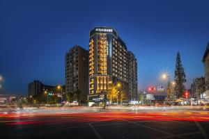 a tall building in a city at night at Atour Light Hotel Chengdu Shuangliu Airport Jinhua Road in Chengdu