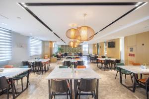 a restaurant with tables and chairs in a room at Atour Hotel Presidential Residence Nanjing in Nanjing