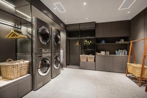 a laundry room with three washer and dryer at Atour Hotel Chengdu Jinhua Wanda Liulichang in Chengdu