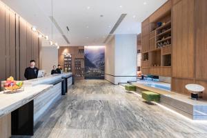 a lobby of a hotel with a bar and people at Atour Hotel Ningbo Yinzhou Wanda Mingzhouli in Ningbo