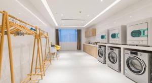 a laundry room with a washer and dryer at Atour Hotel Changjiang North Road Wuxi in Wuxi