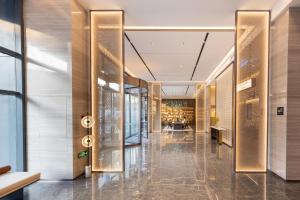 een lobby van een gebouw met glazen wanden bij Atour Hotel Wuhan Chuhe Han Street Hongshan Plaza in Wuhan