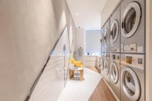 a laundry room with washing machines and a yellow chair at Atour Hotel Zhongshan North Station V-PARK Plaza in Zhongshan