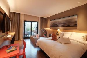 una camera da letto con un letto con sopra degli animali di peluche di The Suites Hotel Jeju a Seogwipo