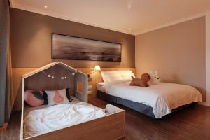 a bedroom with two beds and a teddy bear on the bed at The Suites Hotel Jeju in Seogwipo