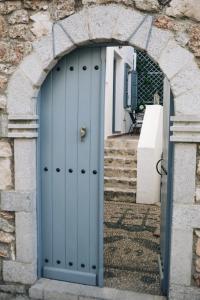 un arco con una porta blu in un edificio di Summer Villa Zefiros, close to Kaiki beach a Spetses