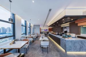 a restaurant with tables and chairs and a bar at Atour X Hotel Nanjing Jiangning Future Internet Town in Jiangning