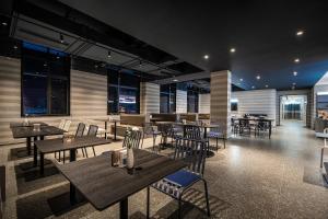 a restaurant with wooden tables and chairs and windows at Atour Light Hotel Chengdu Shuangliu Airport Jinhua Road in Chengdu