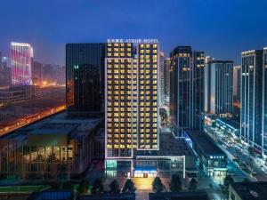 un edificio iluminado en una ciudad por la noche en Atour Hotel Chengdu Xibo City Shuzhou Road en Chengdú