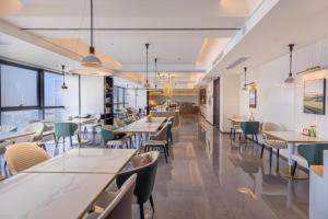 a restaurant with tables and chairs and a cafeteria at Atour Hotel Wuhan Chuhe Han Street Hongshan Plaza in Wuhan