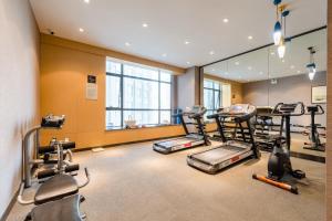 a gym with several treadmills and elliptical machines at Atour Hotel High Speed Railway Station Maoming in Maoming