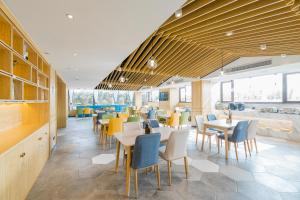 a restaurant with tables and chairs in a cafeteria at Atour Hotel Changjiang North Road Wuxi in Wuxi