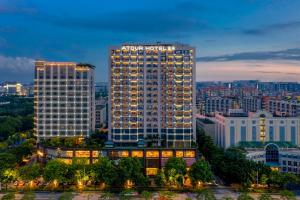 un grand bâtiment avec un hôtel aania en haut dans l'établissement Atour Hotel Guangzhou Huadu Financial Center, à Huadu