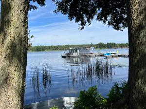 a dock on a lake with a boat in the water at Hausboot STEHEND Grey Pearl in Fürstenberg