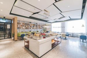 a lobby with a counter and chairs in a building at Atour Hotel Nanjing South Station in Nanjing