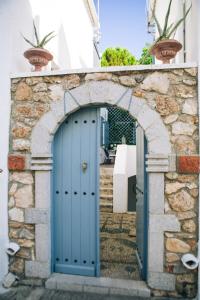 Un arco con una puerta azul en una casa en Summer Villa Zefiros, close to Kaiki beach, en Spetses