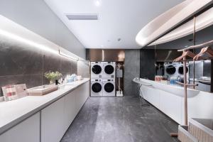 eine Waschküche mit drei Waschmaschinen und Trockner in der Unterkunft Atour Light Hotel Zhuhai Jinwan Airport Aviation 