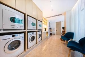 a laundry room with three washer and dryers at Atour Light Hotel Zhuhai Lovers Road Grand Theater in Zhuhai