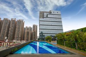 a swimming pool in front of a tall building at Atour Hotel Foshan Nanhai Qiandeng Lake Guicheng in Nanhai
