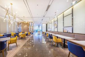 a dining room with tables and yellow chairs at Atour Hotel Zhongshan North Station V-PARK Plaza in Zhongshan