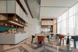 a restaurant with tables and chairs and a kitchen at Atour Hotel Ningbo Zhenhai New City in Ningbo