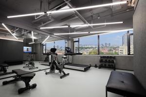 - une salle de sport avec des appareils de cardio-training et une grande fenêtre dans l'établissement Atour Light Hotel Huzhou Deqing Moganshan, à Deqing