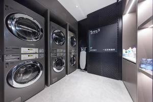 a laundry room with four washing machines in it at Atour Light Hotel Shenzhen North Station East Plaza in Lung Wa