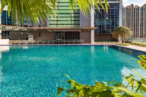 a swimming pool in front of a building with tall buildings at Atour Hotel Zhongshan North Station V-PARK Plaza in Zhongshan