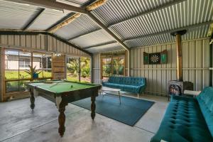 uma sala de estar com uma mesa de bilhar e uma lareira em Christies Garden - A Beachside Entertainer's Gem em Port Noarlunga
