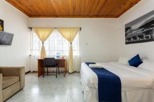 a bedroom with a bed and a desk and a window at Bonsai Village in Nairobi +157 photos